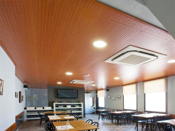 Falso techo de madera perforado en la sala de un restaurante