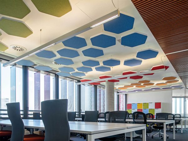 Panneaux phonoabsorbants hexagonaux au plafond dans un bureau
