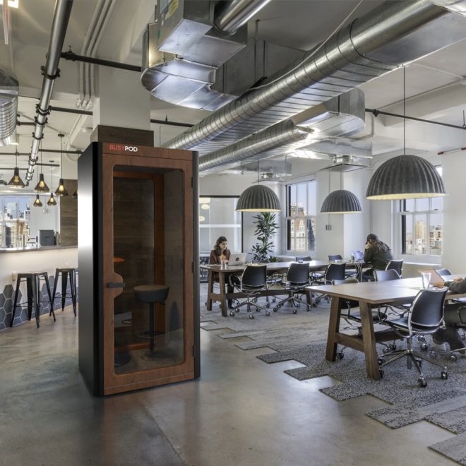 Individual black phone booth in a shared space