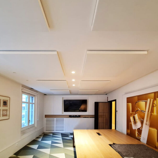 Paneles acústicos a techo revestidos en tejido blanco en sala de reuniones