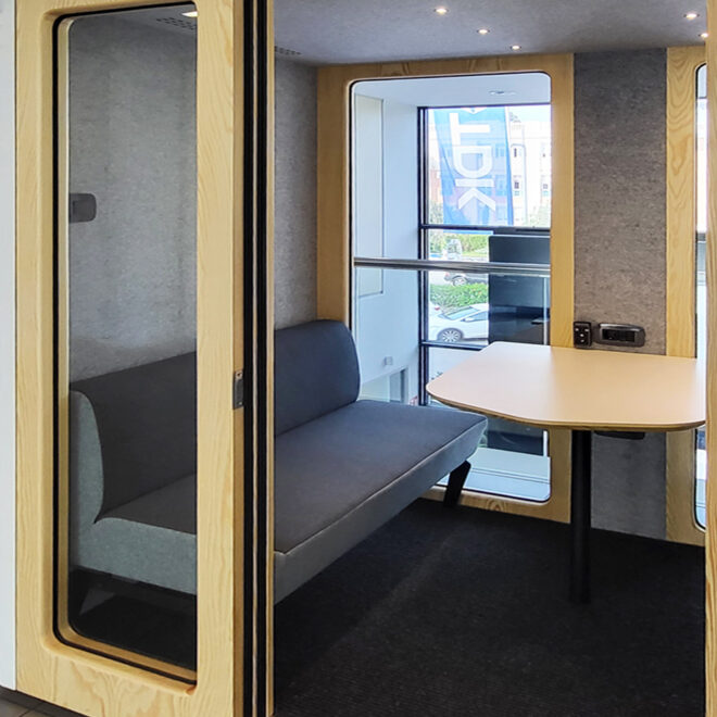 Cabina acustica per riunioni di lavoro con telaio in legno e divanetti interni